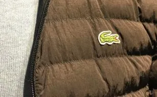 Bruin gewatteerd jack met logo naast een grijze trui