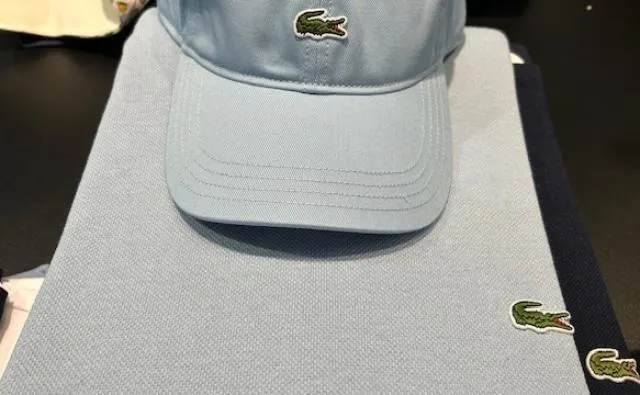 Lichtblauwe Lacoste-pet op een bijpassende polo